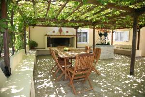 a patio with a table and chairs under a pergola at Villa Carina in Kounopetra