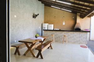 a kitchen with a wooden table and benches in a room at Casa Temporada Nosso Recanto Piscina aquecimento Solar in Olímpia