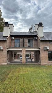 a large brick house with a balcony and a yard at Terroir Village - Complejo de 4 duplex in Guaymallen