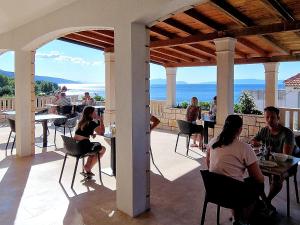 un gruppo di persone seduti ai tavoli su un patio di Pansion Braco a Zavala