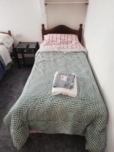 Un dormitorio con una cama con un libro encima. en Acuario 2, en Presidencia Roque Sáenz Peña