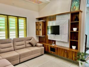 a living room with a couch and a flat screen tv at Cliffnest by Nivara 4BHK Luxury Villa in Varkala in Varkala