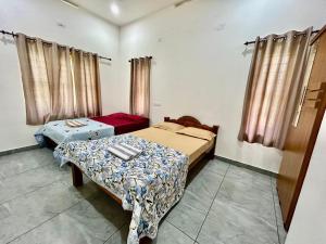 a bedroom with two beds and a table in it at Cliffnest by Nivara 4BHK Luxury Villa in Varkala in Varkala