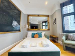 ロンドンにあるStylish Duplex Condo Opposite Hyde Parkのベッドルーム(鏡付きの大きな白いベッド1台付)