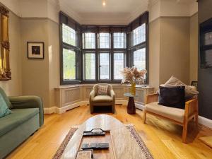 ロンドンにあるStylish Duplex Condo Opposite Hyde Parkのソファと椅子とテーブルのあるリビングルーム