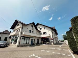 a building with a car parked in a parking lot at Cazare Vicoveancaa in Vicovu de Jos