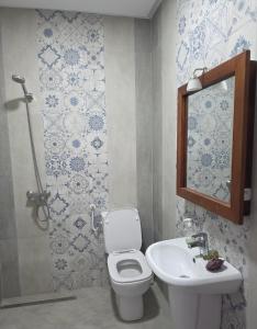 a bathroom with a toilet and a sink at American Style Triplex in Mahdia