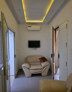 a living room with a couch and a tv at American Style Triplex in Mahdia