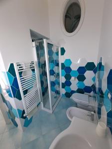 a blue and white bathroom with a toilet and a mirror at Casa Belle Vue in Furore +26 photos