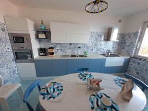 a blue and white kitchen with a table and chairs at Casa Belle Vue in Furore