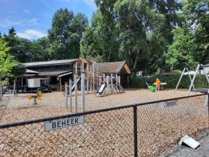 a playground in front of a building with a fence at Groene Oase in Epe