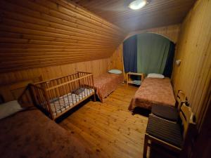 a room with two beds in a wooden room at Ranna Resort Hostel in Pärnu