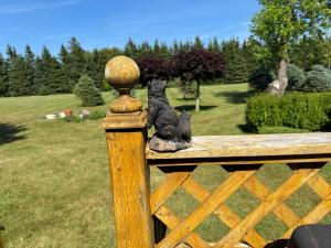Ein Teddybär sitzt auf einem Holzzaun in der Unterkunft Hidden Acres Cottages in Cavendish