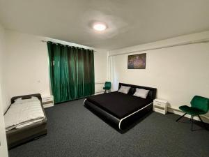 a bedroom with a bed and a green curtain at Luna Apartmán in Strekov