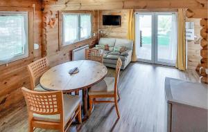 ein Wohnzimmer mit Tisch und Stühlen und einer Couch in der Unterkunft Agréable Chalet Proche Du Lac in La Teste-de-Buch