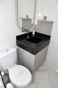 a bathroom with a white toilet and a sink at Comforto e tranquilidade in Franca +24 photos