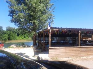a restaurant with a deck next to a river at Hotel Restaurant du Pont de Ners in Boucoiran-et-Nozières +12 photos