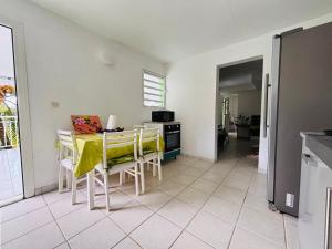 a kitchen and dining room with a table and chairs at Le Havre de paix in Le Robert