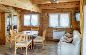 ein Wohnzimmer mit Tisch und Stühlen und einer Couch in der Unterkunft Agréable Chalet Proche Du Lac in La Teste-de-Buch