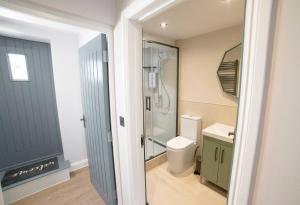 a bathroom with a shower and a toilet and a sink at Holdens Cottage in Whitstable +21 photos