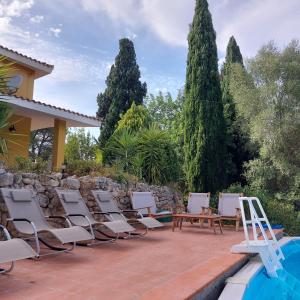 a row of chairs on a patio next to a pool at Il Verdone in Usini