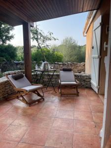 une terrasse avec deux chaises et une table dans l'établissement Deux mini villas distancees 10 metres pour 6 personnes, à Saint-Florent