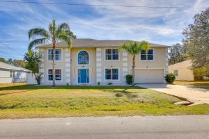 a house with palm trees in front of it at Coastal Retreat - Roomy, Relaxing, Pool in Palm Coast