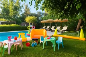 a group of plastic chairs and tables and a pool at Villa Small Paradise private pool, jacuzzi, BBQ, complete privacy in Ialysos