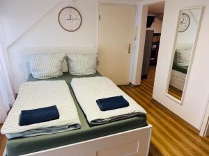 two beds in a room with a clock on the wall at Apartment mit Balkon an der Mosel in Koblenz-Güls in Koblenz