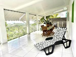 a screened in porch with a table and chairs at Le Havre de paix in Le Robert