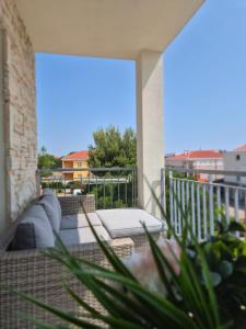a balcony with couches and chairs on a patio at Blue Breeze Apartments in Privlaka