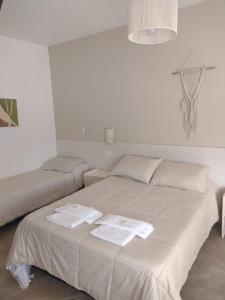 a bedroom with a bed with two towels on it at Hotel Alumine in Villa Cura Brochero