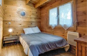 ein Schlafzimmer mit einem Bett in einer Holzhütte in der Unterkunft Agréable Chalet Proche Du Lac in La Teste-de-Buch + 12 Fotos