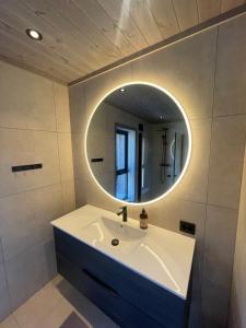 a bathroom with a white sink and a mirror at Moderne og romslig familiehytte i Stryn in Stryn