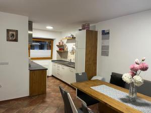 a kitchen and dining room with a table and a refrigerator at FAMILY HOUSE Pri Kovaču in Soča