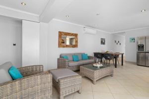 a living room with wicker furniture and a table at Den Laman Condominium Shark in Kralendijk