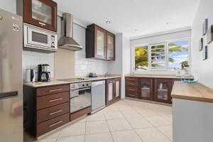 a kitchen with wooden cabinets and a large window at Den Laman Condominium Shark in Kralendijk +33 photos