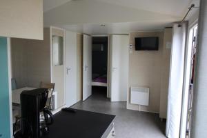 Zimmer mit einem Schreibtisch und einem Zimmer mit einem Bett in der Unterkunft Land's Hause Bungalows par La Conciergerie Française Emplacement S6 in Pataias