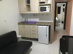 una pequeña cocina con fregadero y nevera. en Apartamento Beira Mar Manaíra en João Pessoa