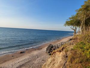 a sandy beach next to the ocean on a cliff at Dębina Lounge 20 Apartamenty in Debina