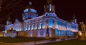 a large building lit up in blue at night at Large Room Near City Centre in Belfast