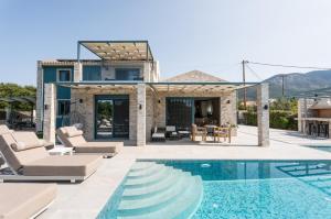 a villa with a swimming pool and a house at Villa Prestige Karavados in Karavadhos
