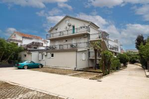 a house with a car parked in front of it at Exclusive Rooms in Jadranovo