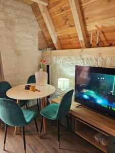 a dining room with a table and a tv at Malii Rajj Žabljak in Žabljak
