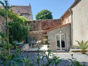 a garden with a patio with a table and chairs at La petite maison de poncho in Le Blanc