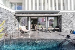 a house with a swimming pool next to a stone wall at Aroeira Luxury Azul Villa, Lisboa, Beach, Surfing, Golf, Exploring, Hiking, Fishing in Charneca