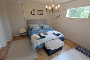 a bedroom with a bed and a chandelier at Pet Friendly Retreat - Sleeps 8 with Sauna in Koivisto