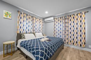a bedroom with a bed with blue and yellow curtains at Tranquil Escape- Spa Bath & Pool for One or Couples in Houston