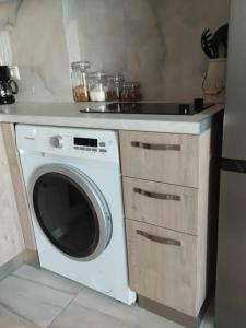 a kitchen with a washing machine and a counter at Thanos Cozy Apartments in Skala Kallonis