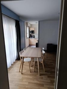 a table and chairs in a room with a kitchen at Beau T2 hyper centre face à la gare in Lille